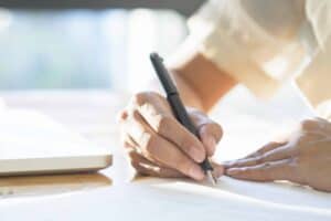 寫作簽名、合約或文件的手部特寫畫面.