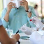 口罩與採血設施的醫療檢查場景，展現專業醫療團隊為外籍勞工進行健康檢測。.