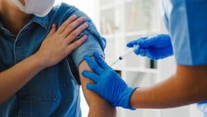 疫苗接種，醫護人員幫助外勞注射COVID-19疫苗，保障海外勞工健康與安全。.