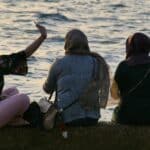 外勞女性朋友在海邊聊天放鬆的風景.