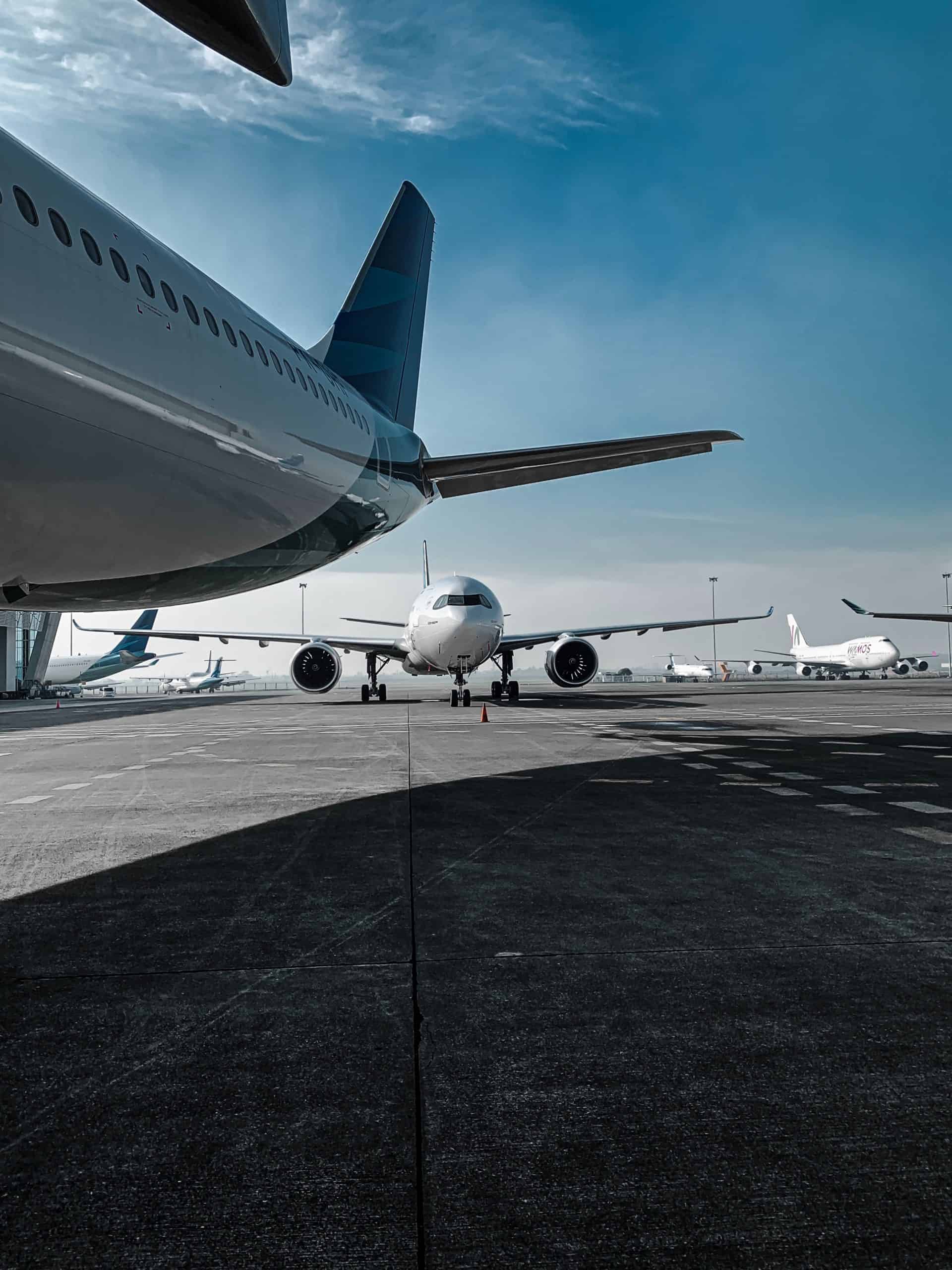 飛機停靠在機場跑道上，展現國際外勞與全球旅行的趨勢。.