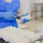 奶酪製作過程，外勞在工廠手工切割奶酪，展現精湛技藝與專業技能。.