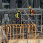 施工工人正在搭建工程腳手架，展現21世紀全球外勞集團的專業技術。.