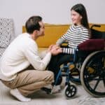 護理照護外勞與殘障人士互動，展現關愛與支持的情感連結。.