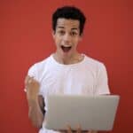 快樂男子用筆記本工作成功的喜悅.