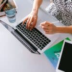 繁忙女性使用筆記型電腦工作，展現專業形象。.