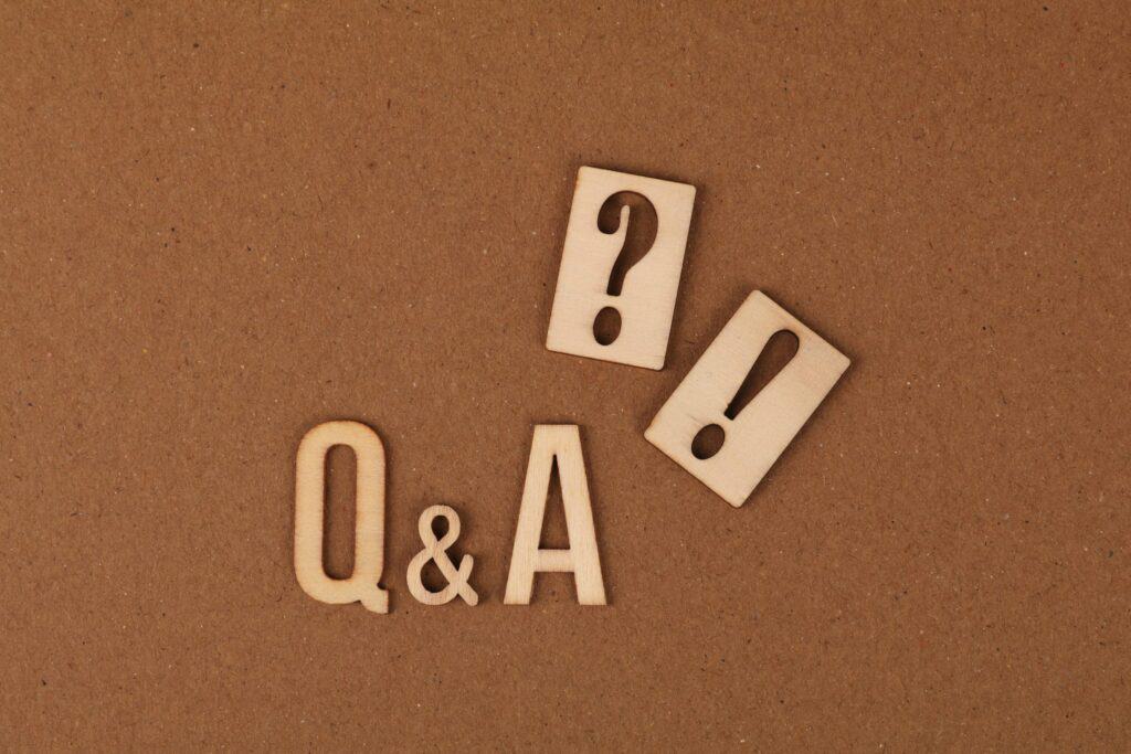 Question and exclamation mark wooden tiles on brown surface.
