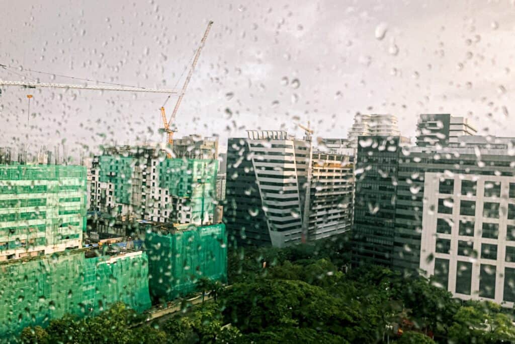 多雨天城市高樓建築景觀，窗戶上有水滴，展現繁忙都市景象。.