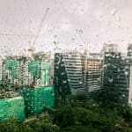 多雨天城市高樓建築景觀，窗戶上有水滴，展現繁忙都市景象。.