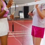 羽毛球運動中的女性選手和教練交流，展現專業與熱愛運動的精神。.