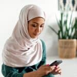 21世紀全球外勞集團，女性使用手機，展現多元文化與全球化外勞服務。.