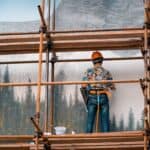 工地高空作業中的工人，展現專業建築和外勞服務的形象。.