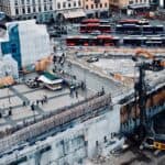 繁忙城市建設工地，施工中的混凝土拆除與工程機械作業場景。.