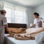 打掃床鋪的外國外勞與台灣女護理師合作整理床鋪。.