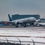 空中客車A350降落在雪地跑道，展現國際航空運輸與世界外勞傳送的重要性。.