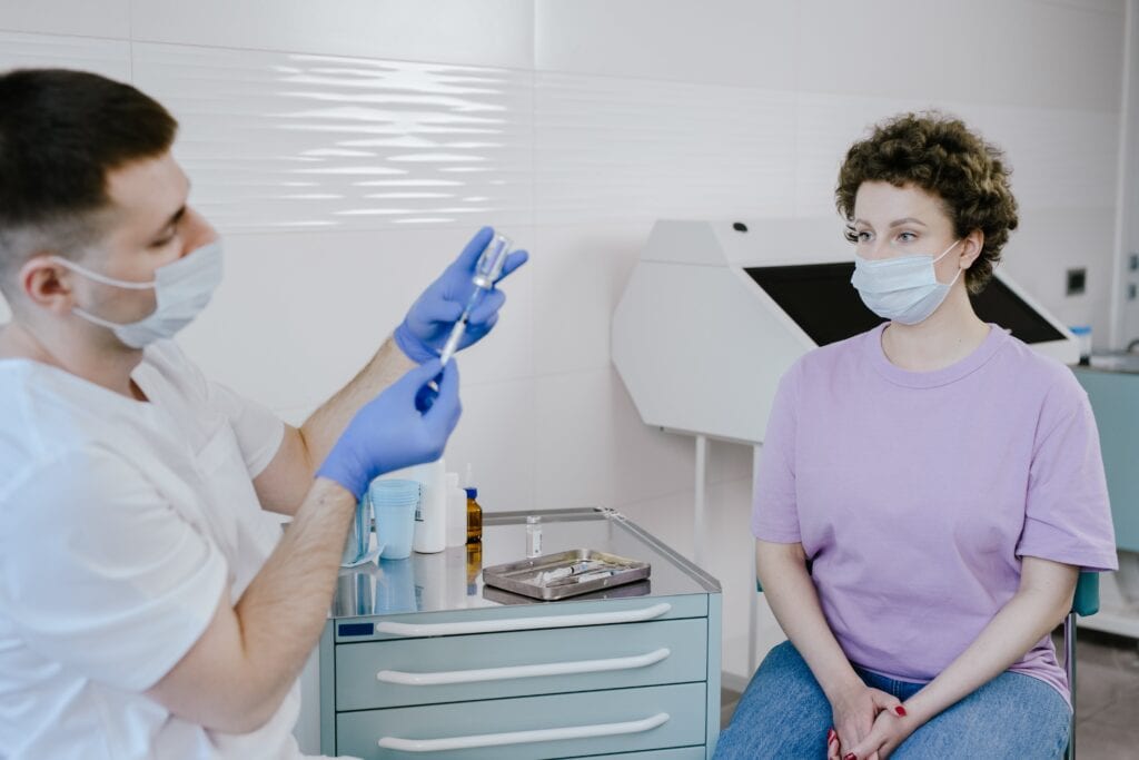 耐心檢查疫苗接種的醫護人員與女性患者的醫療過程圖.