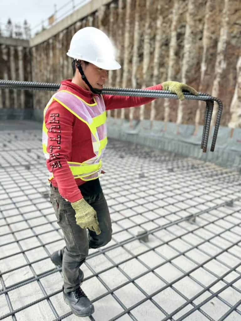 鋼筋施工工人在建設工地上架設鋼筋，展示專業外勞技術於21世紀全球外勞集團。.