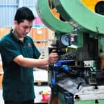 專業外勞技師在工廠操作大型機械設備.