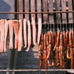 熟食腸粉和烤香腸掛在戶外晾曬，展現多元國際外勞集團特色。.