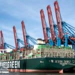 貨櫃船在港口作業，展現21世紀全球外勞集團的國際物流與人力資源合作。.