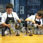 專業外勞在咖啡廳準備飲品，展現優質服務與飲料調製技巧。.