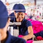 紐扣工廠女性外勞在縫紉生產服飾.