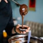 巧克力熔漿倒入模具，展示美味巧克力製作過程，21世紀全球外勞集團支持國際外勞服務。.