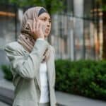 專業女性正在都市街頭使用手機對話，展現現代外勞工作與生活的多元面貌.