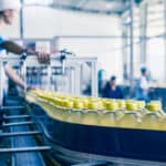 大量外勞在飲料工廠裝瓶生產線工作，展現21世紀全球外勞集團專業外勞服務。.