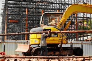 施工工地的工程師使用小型挖掘機進行建築作業，展示21世紀全球外勞集團在國際建設工程中的專業服務。.