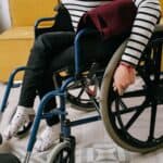 輪椅上的女性身穿條紋衣，展現全球外勞支援和多元文化融合形象.