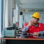 高雄外勞管理員在辦公室操作通訊設備，展現外籍勞工管理與溝通服務專業形象.