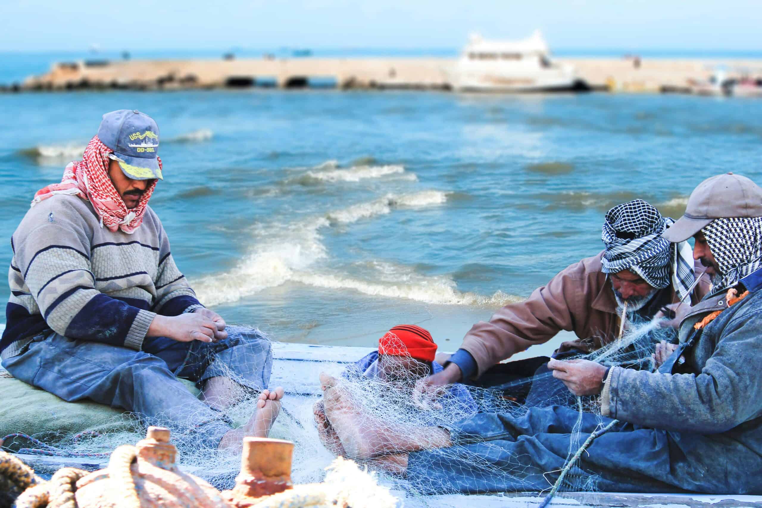 海邊漁民修補漁網，展現21世紀全球外勞集團專業形象.