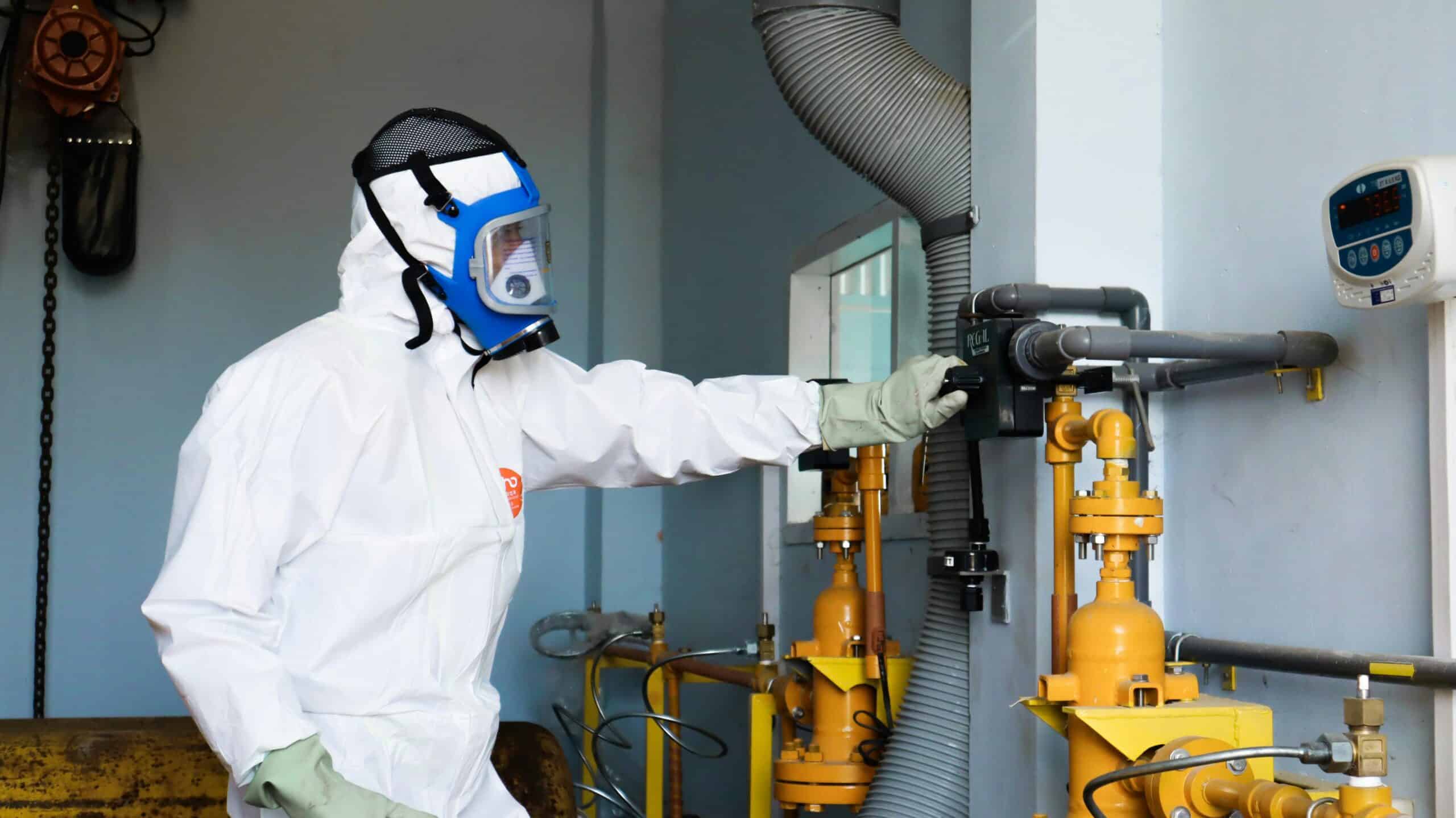 高危險作業工人在工廠檢查氣體管線，專業安全防護裝備，確保工作安全與環境保障。.