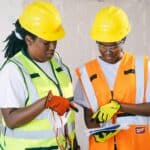 安全檢查施工工人穿著安全帽與背心陣列在建築工地。.