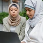 專注討論的兩位女性外勞，展現專業合作氛圍。.