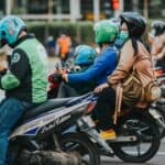 騎摩托車的多國外勞群，展示全球外勞集團多元文化與合作。.