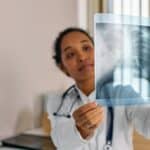 成熟外勞醫護人員檢查X光片，專業醫療服務與海外人力資源供應。.