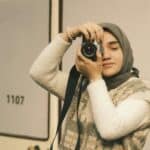 攝影師女性穿著圍巾橫跨自攝風格照現代時尚，展現自信與創意，象徵21世紀全球外勞集團的多元文化與專業精神.