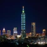 台北101夜景，燈光璀璨的摩天大樓，彰顯台灣創新與經濟實力，吸引國際外勞與投資者目光。.