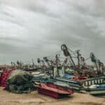 多艘漁船在港邊停泊，海邊漁業活動場景，美麗海景與漁具彰顯台灣渔业特色。.