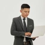 專業男士商務打扮使用筆記型電腦，展現全球外勞集團服務。.