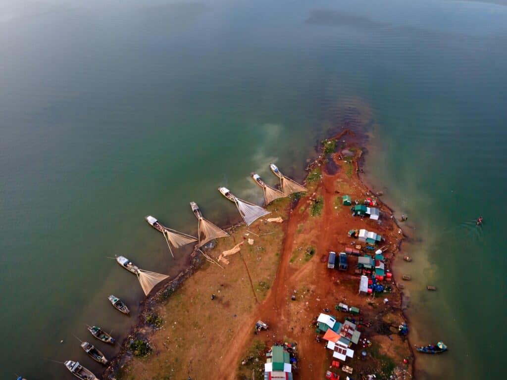 海邊漁村與捕魚船隻的空拍景觀，展現21世紀外勞集團在全球的合作與發展。.