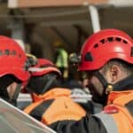 施工安全帽工人交流場景，體現21世紀全球外勞集團專業服務。.