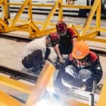 施工作業中的外勞工人，專業焊接於工廠生產線，展現高技術與國際外勞集團優勢.