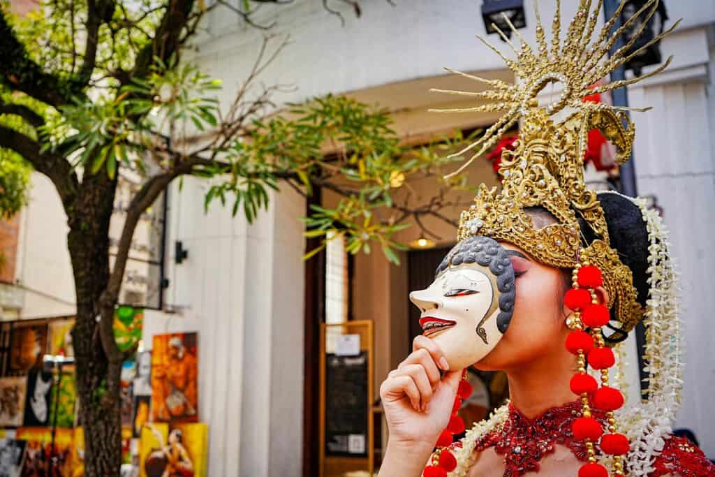 傳統舞蹈面具表演者，穿著華麗服飾，展示文化藝術魅力。.