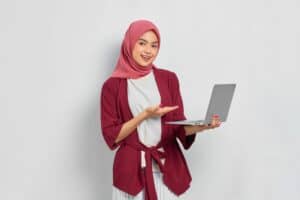 專業女性外籍勞工使用筆記型電腦，展現多元國際人力資源管理。.